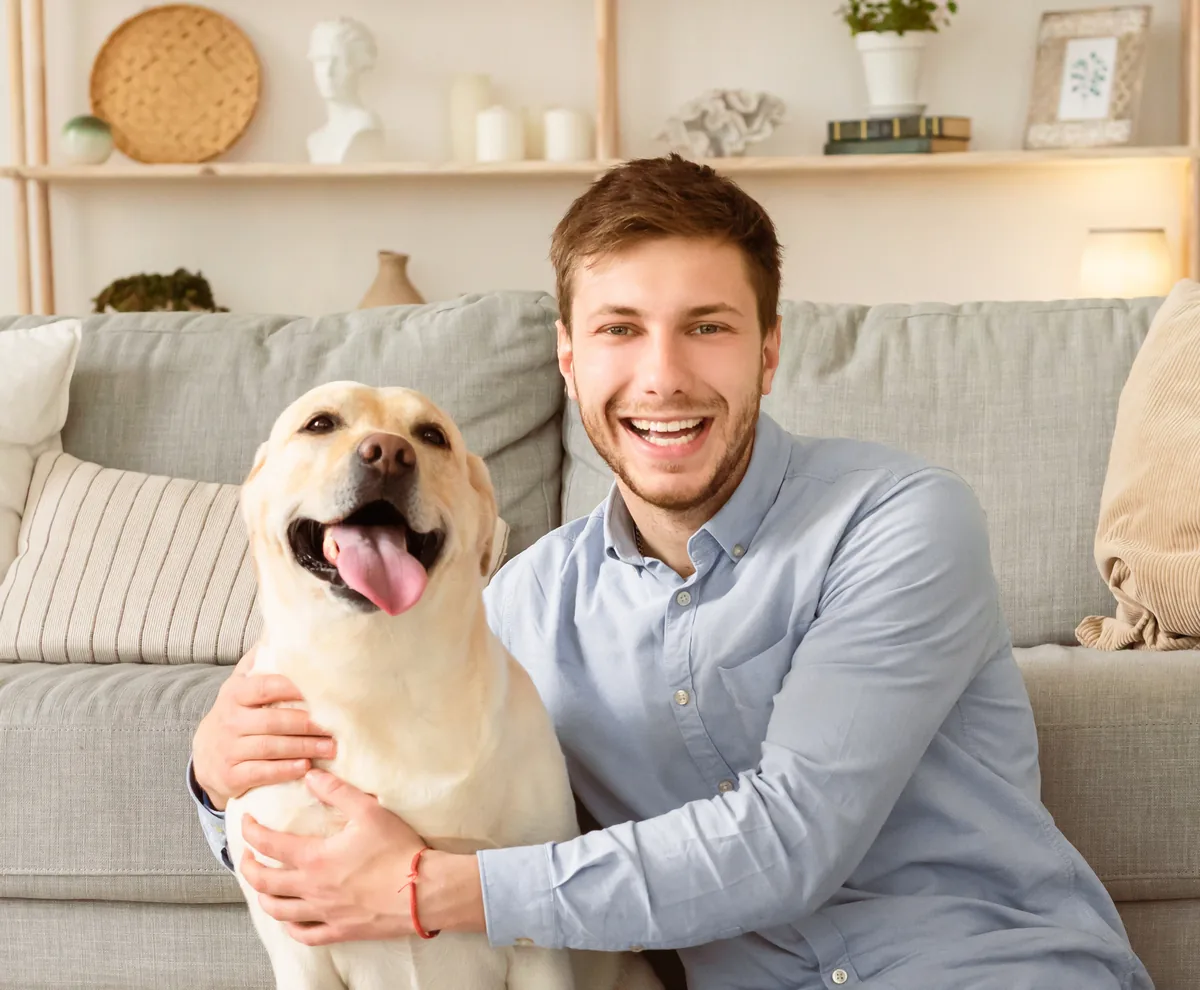 A man relaxing at home with his happy dog